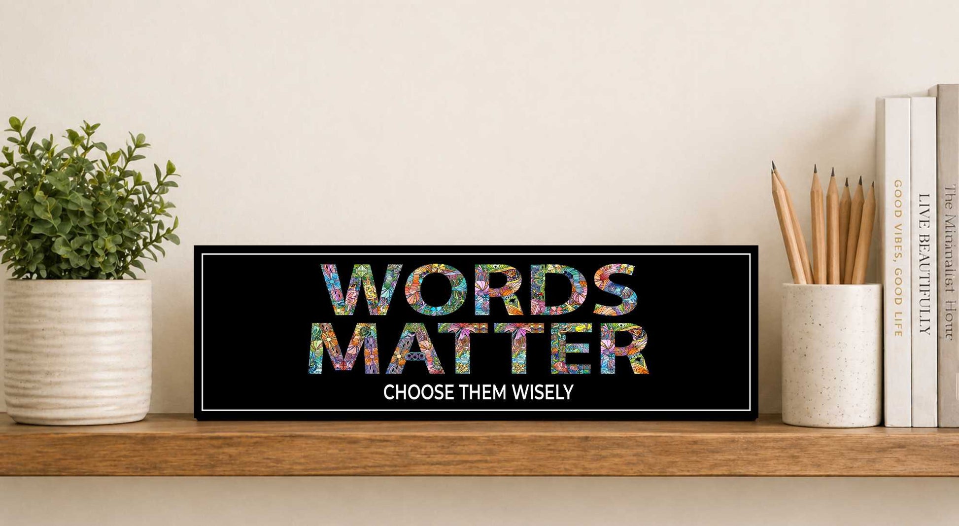 words matter sign displayed on shelf with books and plant 