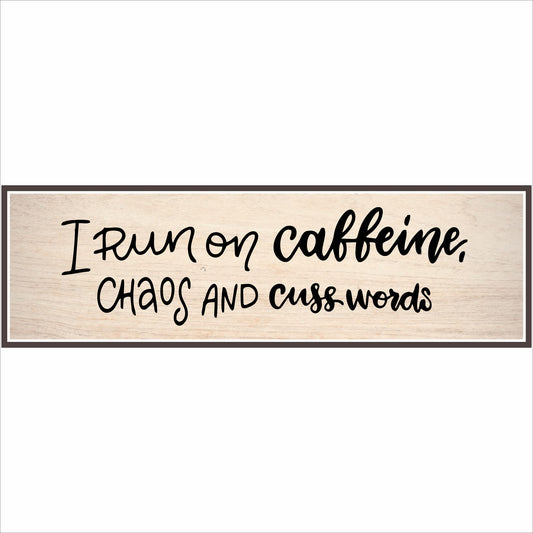 Close-up of funny coffee sign reading I run on caffeine chaos and cuss words