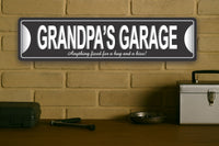 Grandpa’s Garage personalized aluminum sign displayed on a brick wall above a workbench