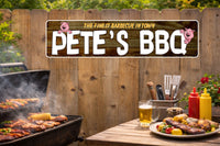 Outdoor backyard barbecue scene with personalized “Pete’s BBQ” sign hanging on a wooden fence above a grill and picnic table.