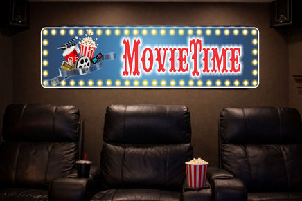 home theater room with leather recliners and a movie time marquee style sign on the wall with printed lights, popcorn and film reel artwork