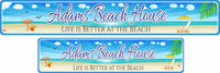 Personalized aluminum beach sign featuring an illustration of a beach with an ocean backdrop, beach chair and umbrella, sea shells, and a beach ball