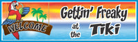 Colorful tiki bar sign with tropical sunset, ocean background, palm trees, parrot illustration, and bold text reading “Gettin’ Freaky at the Tiki.”